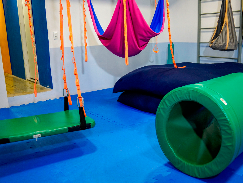 Sala de integração sensorial com balanços e rolos