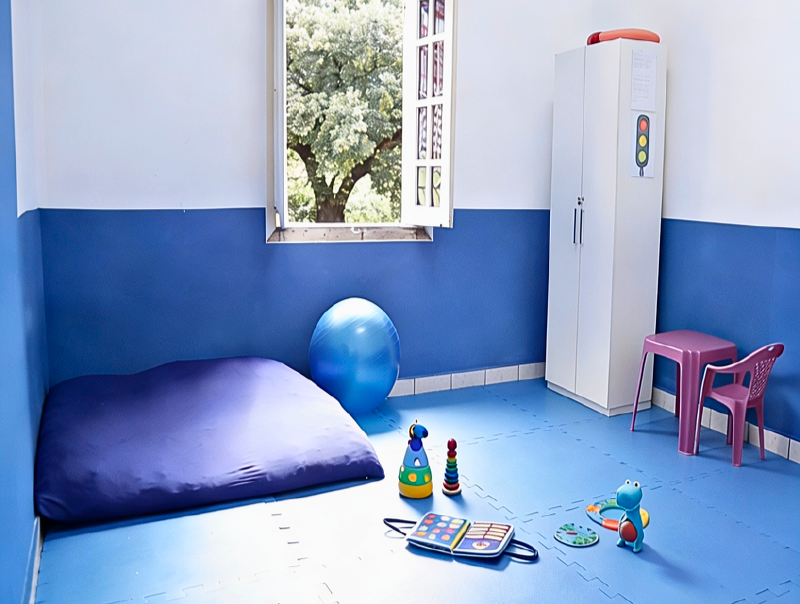 Sala de terapia com colchão, bola e brinquedos pedagógicos